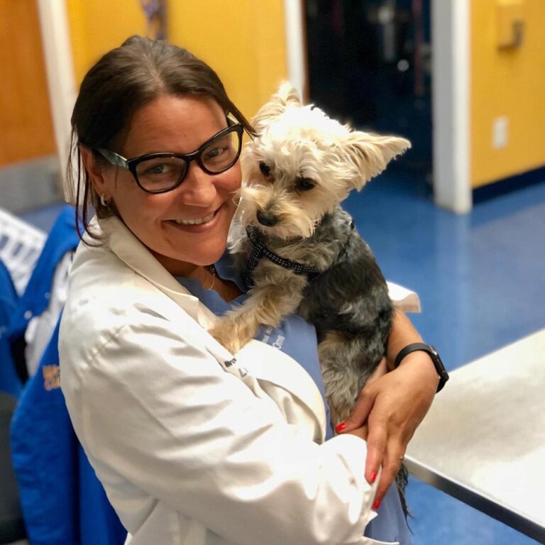 Central Broward doctor smiling while holding a terrier dog
